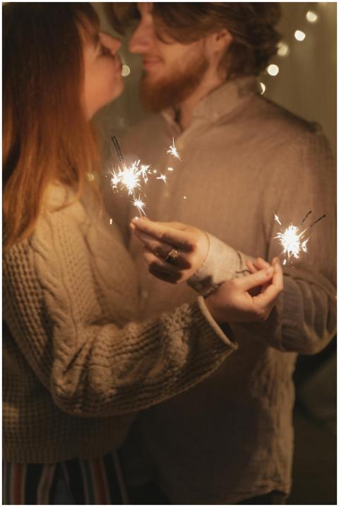 A loving couple shares a moment with sparklers ind