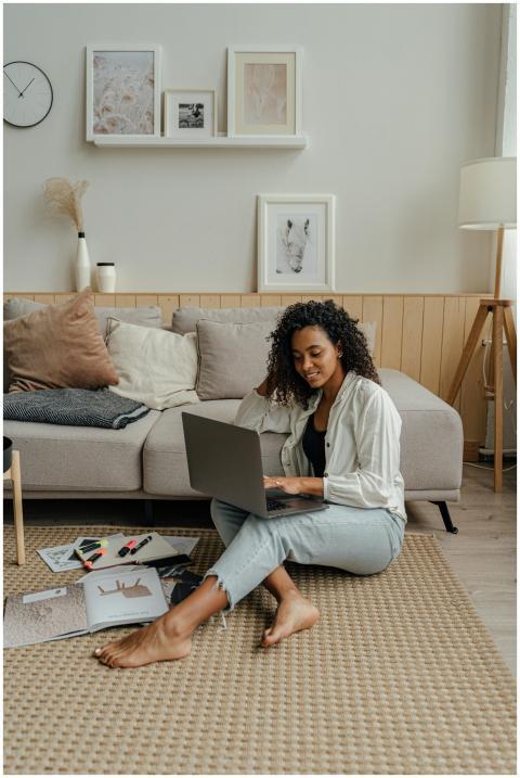 African American woman using laptop on floor in co