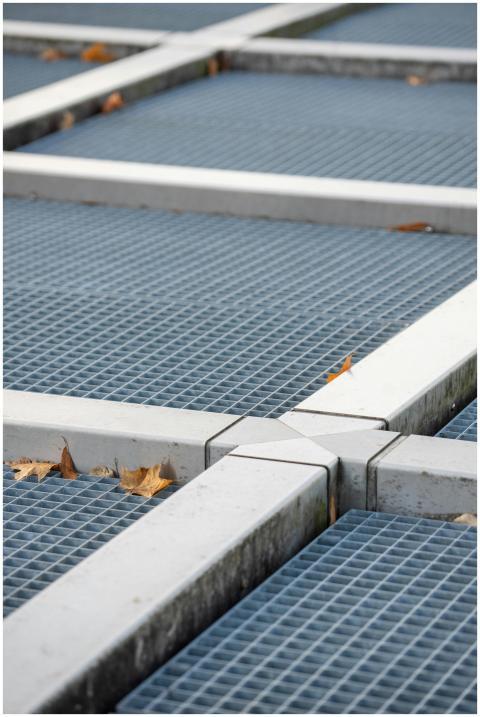 A close-up of a metal grid intersected by white be
