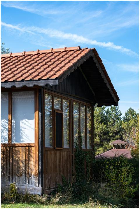 A cozy rustic wooden cottage with a tiled roof in