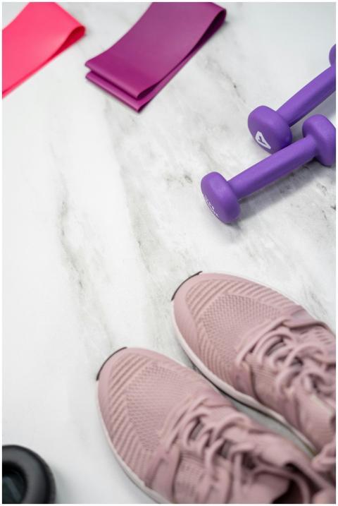 Flat lay of pastel pink fitness gear including sne