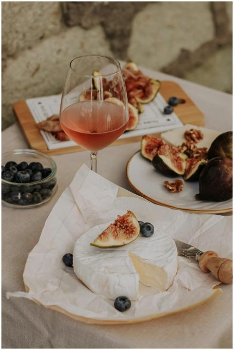 A rustic setup of brie cheese, figs, and rose wine