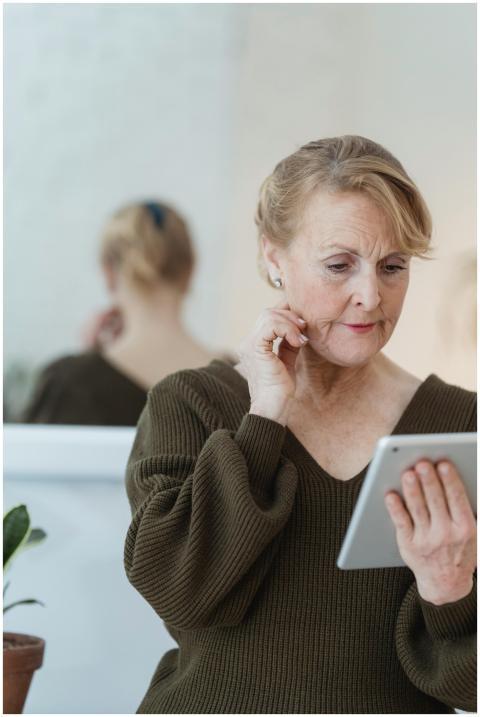 Pensive senior female with cellphone and wrinkled
