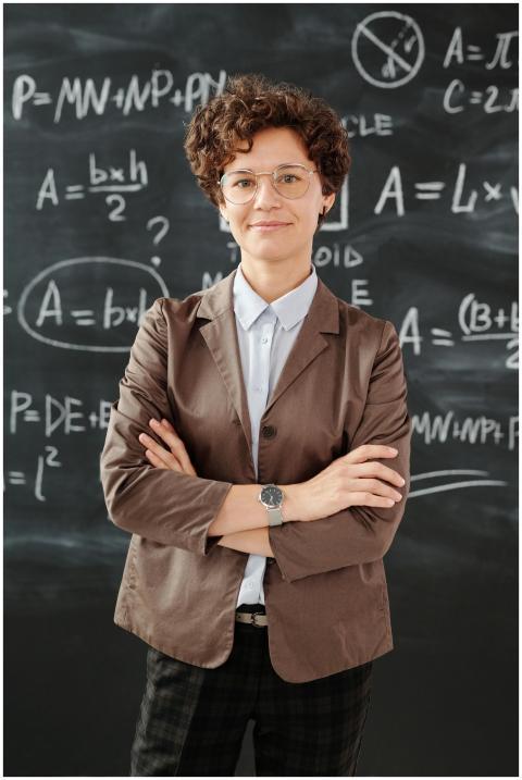 Portrait of a teacher standing in front of a black