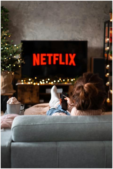 Woman relaxing on sofa with hot chocolate and Netf