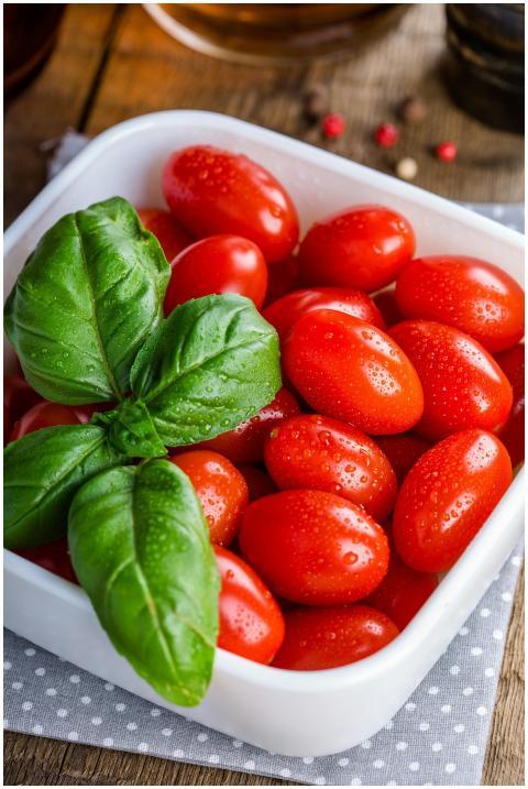 A bowl of vibrant cherry tomatoes garnished with f