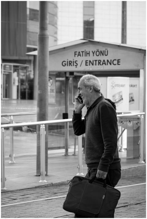 Man talking on smartphone outside an urban train s