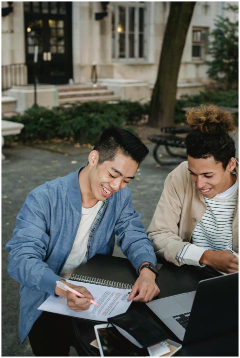 Two college students studying and discussing notes