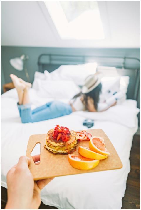 Romantic breakfast in bed with pancakes topped wit