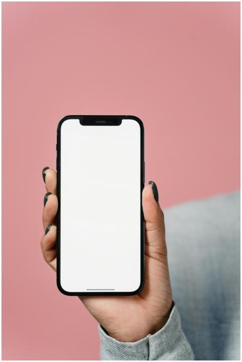 Close-up of a hand holding a smartphone with a bla