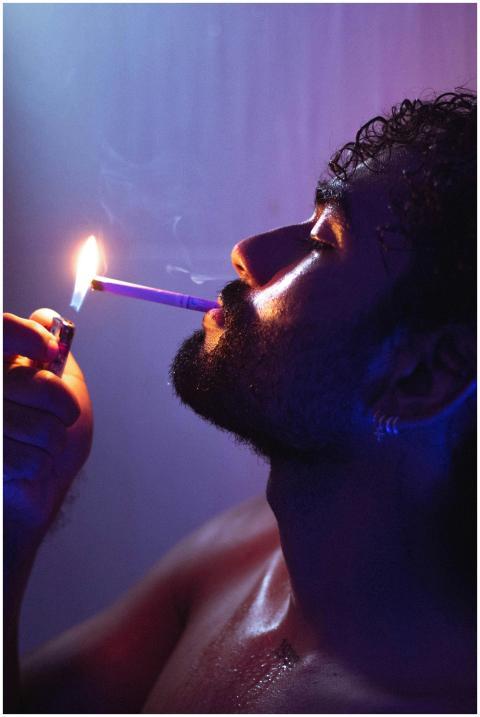 Dramatic neon-lit close-up of a bearded man lighti
