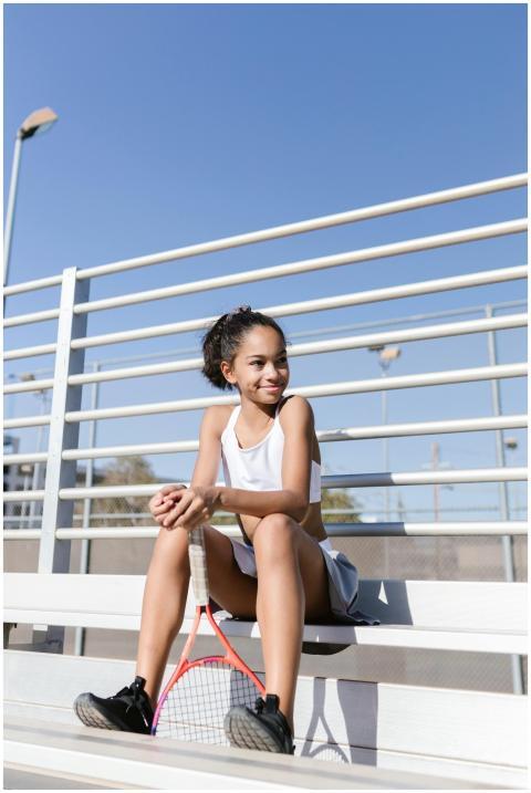 Teen girl in sportswear sitting on bleachers with