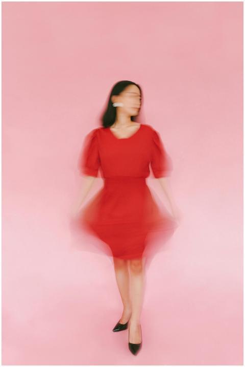 Artistic blurred portrait of woman in red dress ag