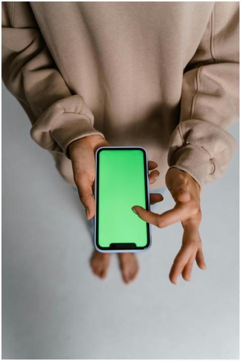 Individual interacts with smartphone, featuring gr