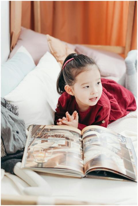 A young child enjoying a book in a comfortable, co