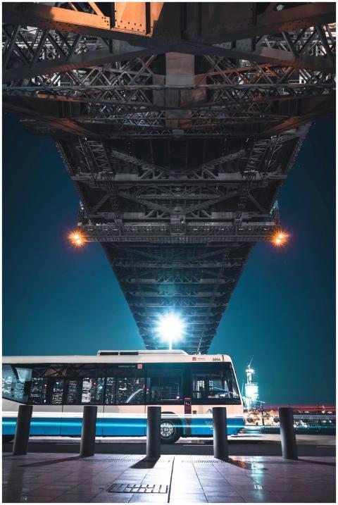 Dramatic night view of a bridge and urban bus unde