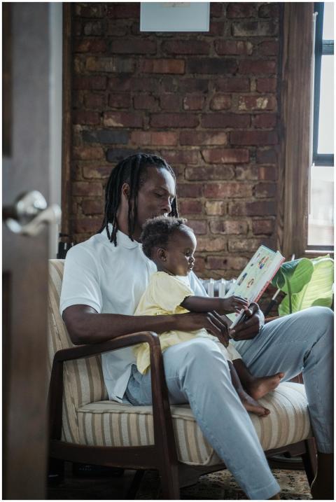 A father and child bonding while reading a book to