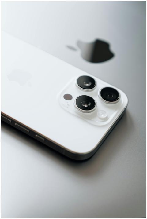 White smartphone with triple cameras lies atop a s