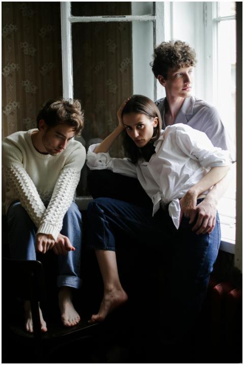 A relaxed indoor portrait of three friends sitting