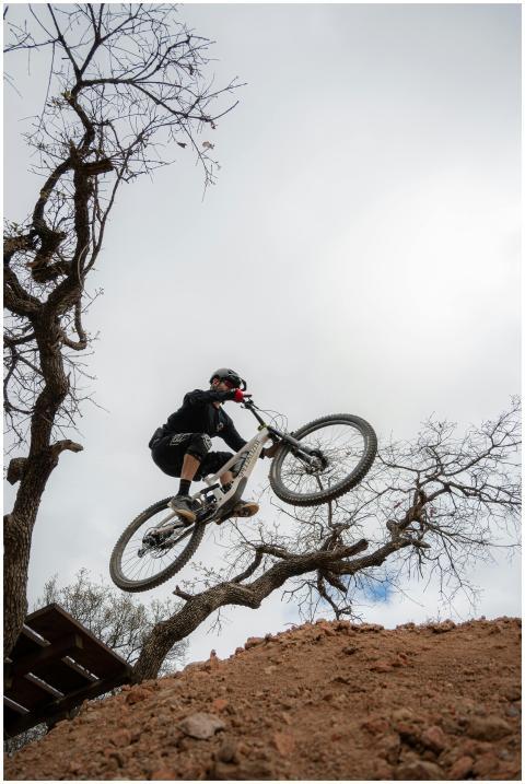 A thrilling moment of a biker jumping over a hill