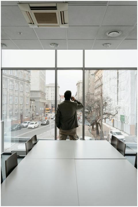 Businessman standing in a modern office, talking o