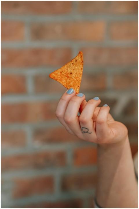 Focused image of a hand holding a nacho chip again