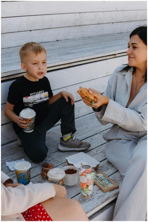 A mother and son sharing a casual outdoor picnic w