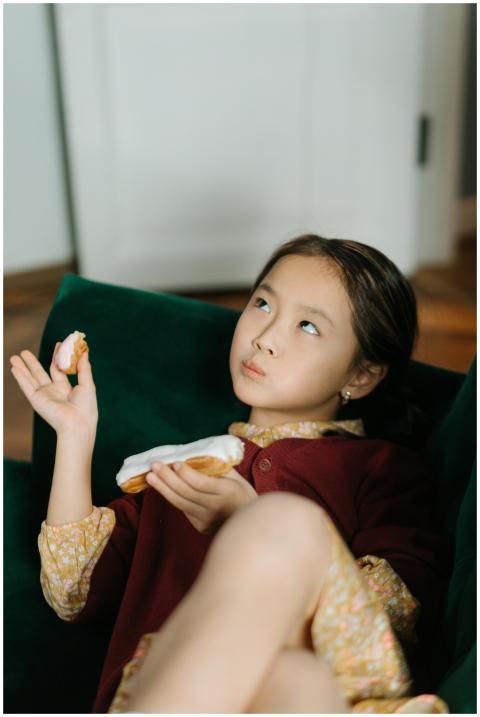 Young girl savoring a delicious eclair in a cozy i