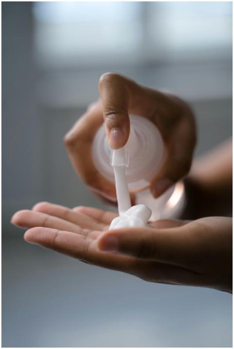 A close-up view of hands applying lotion, ideal fo