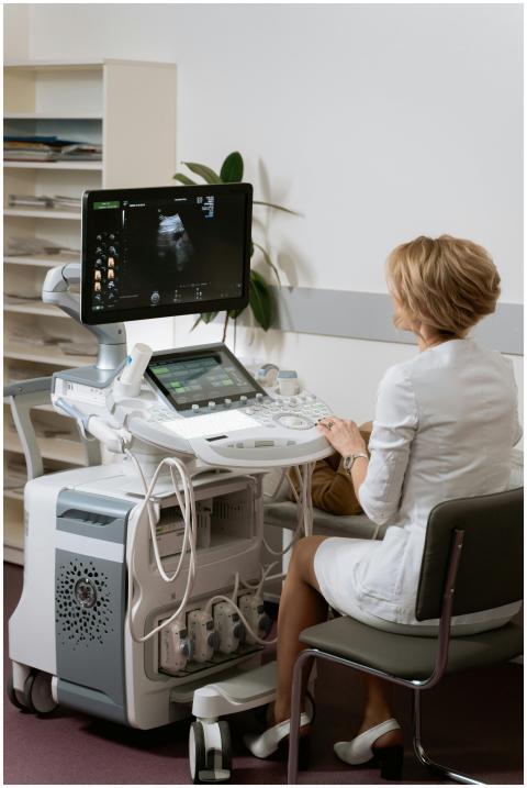 A medical professional operates an ultrasound mach