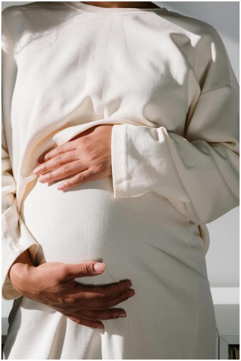 A serene close-up of a pregnant woman cradling her