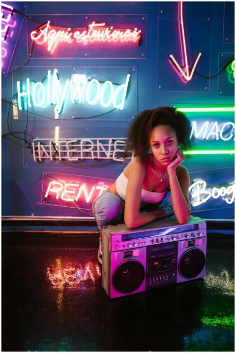Young woman in a neon-lit room with a vintage boom