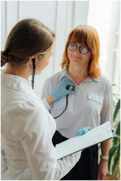 Doctor with stethoscope performing checkup on pati