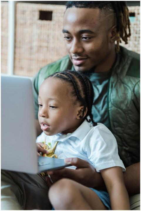 A father and child bonding while using a laptop in