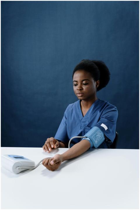 African American nurse checking blood pressure wit