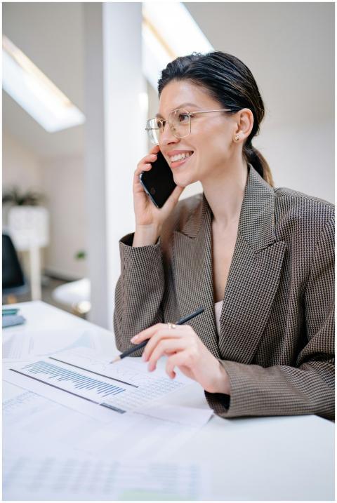 Confident businesswoman talking on smartphone whil