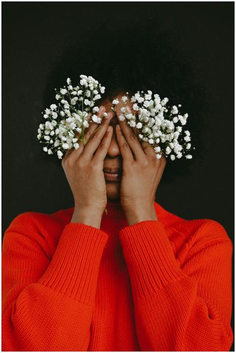 Artistic portrait of a woman covering her eyes wit