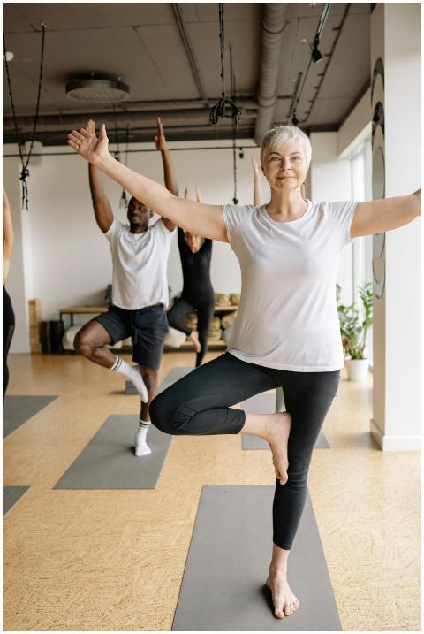 Elderly woman practicing yoga in a calm studio set
