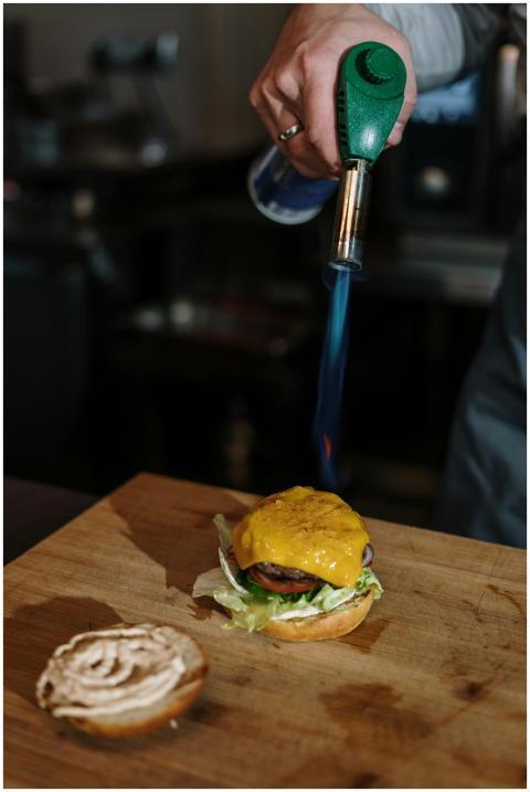 Chef uses a torch to perfectly melt cheese on a go