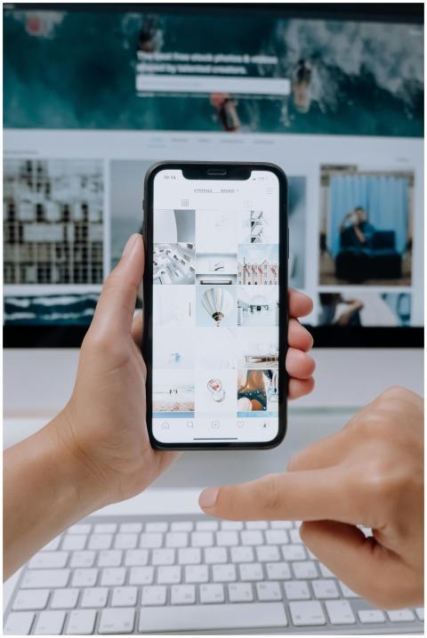 Person using smartphone to browse photos, office d