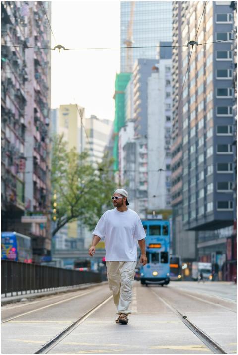 A man walks confidently on a bustling street in Ho