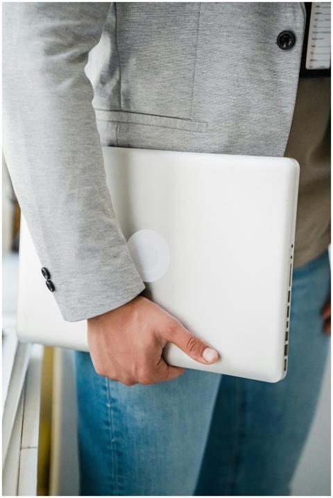 Close-up of a professional holding a laptop in an