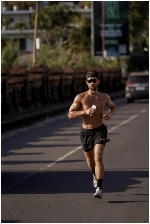 A fit man jogging on a city street showing determi