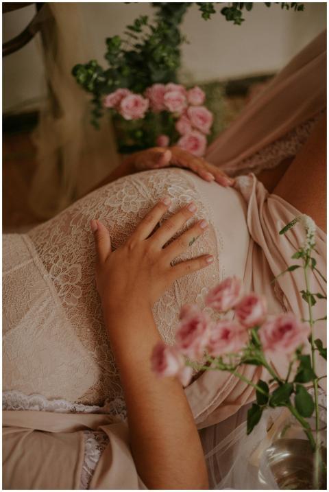 Close-up of expectant mother in lace dress with ha