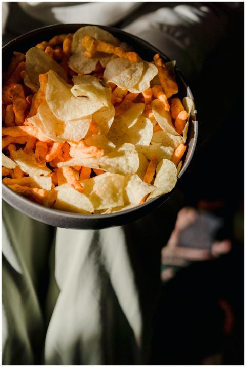 From above of ceramic bowl with delicious chips an