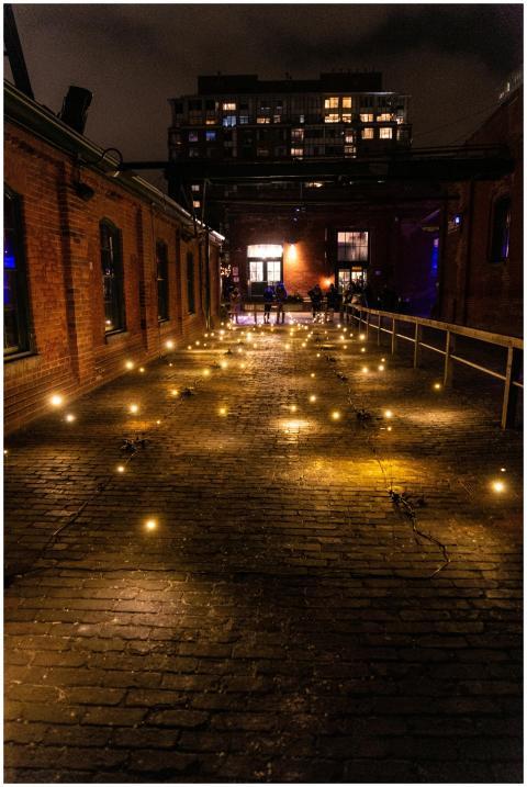 A rustic brick alley illuminated by warm string li