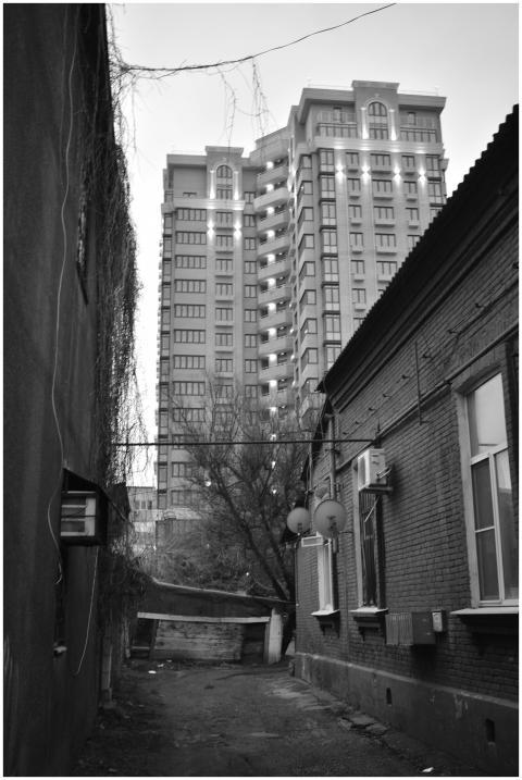 A black and white photo capturing a narrow alley w