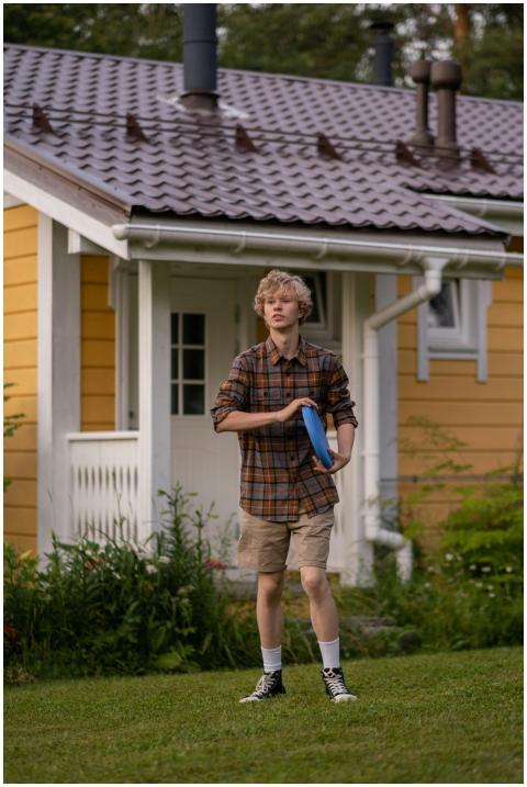 Teenage boy enjoying a game of frisbee in a lush c