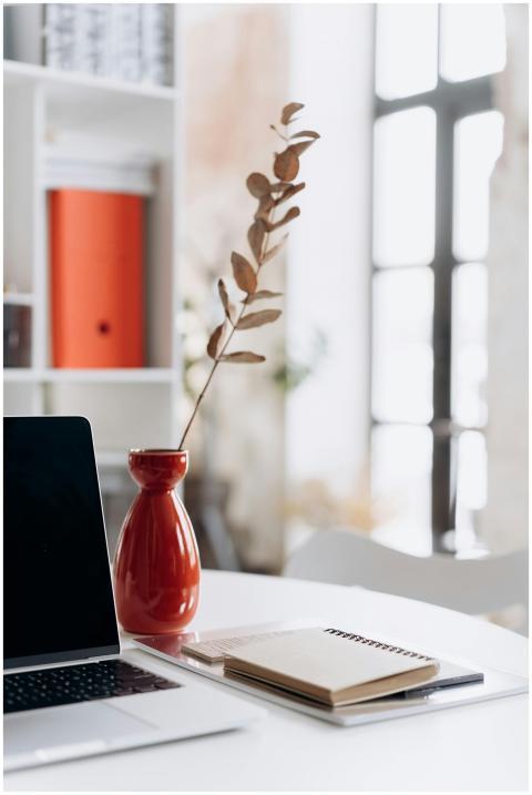 Modern workspace featuring a laptop, notebooks, an