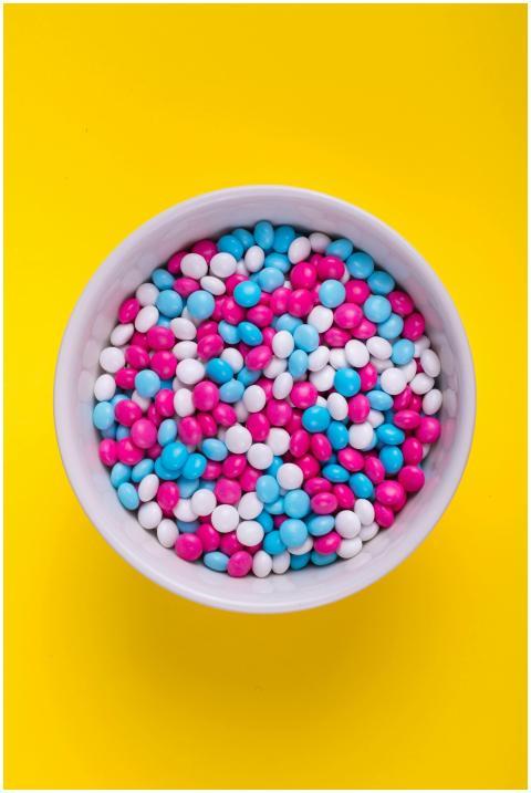 A white bowl filled with colorful candy against a